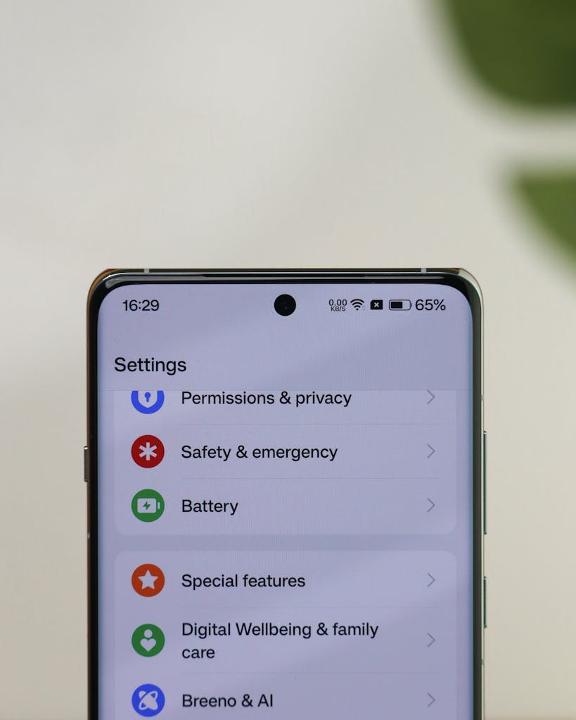 Close-up of a smartphone screen displaying settings menu options like privacy and battery.